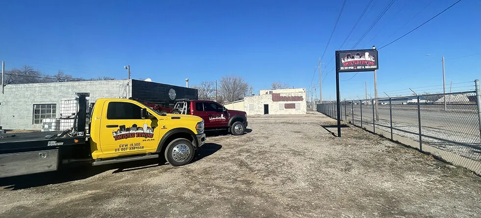 Yellow Twisted Towing Truck Parked Beside The Yard Entrance